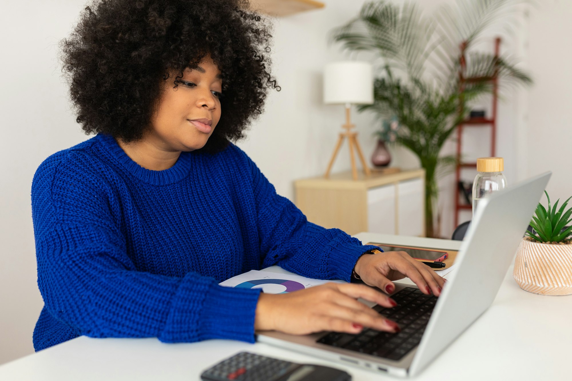 Young black business woman working on laptop computer at home